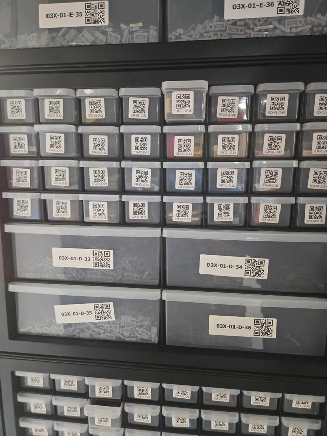 Black 36-drawer cabinet of LEGO parts with 32 small and 4 large drawers, each carrying a QR-code label