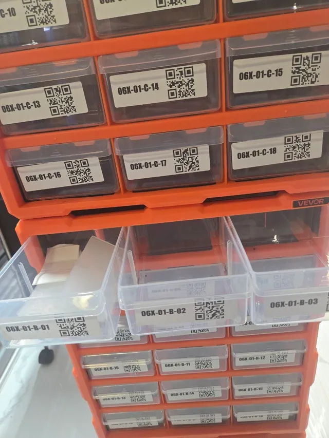 Two stacked orange VEVOR cabinets with QR-labeled drawers, three drawers of the lower cabinet pulled open