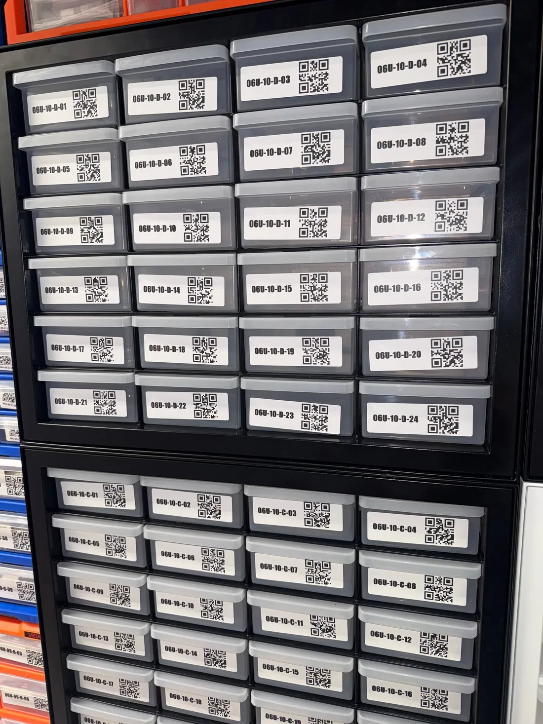 Two stacked black IRIS 24-drawer cabinets, every gray drawer labeled with a location code and QR code