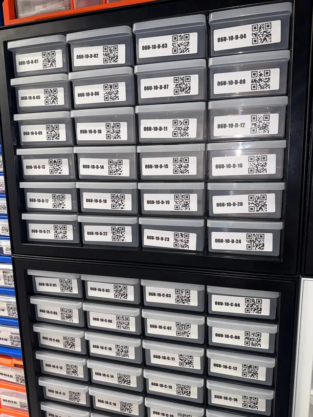 Two stacked black IRIS 24-drawer cabinets, every gray drawer labeled with a location code and QR code